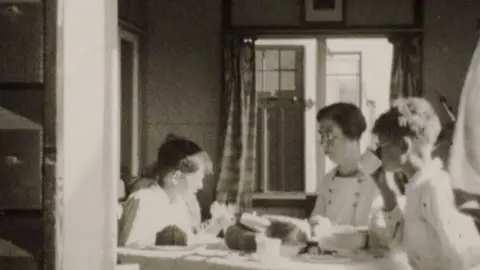 Hoburne Holiday Parks A woman and two boys eating a meal in a chalet
