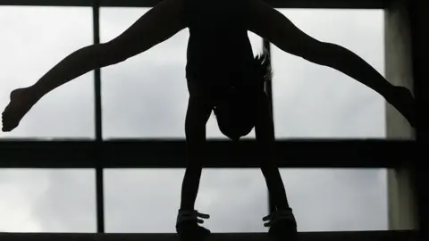 Getty Images A stock picture of a gymnast in black and white. 