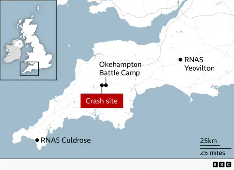 Map of south west England showing the location of a helicopter crash site in Devon, marked with a red label near Okehampton Battle Camp, alongside nearby Royal Naval Air Stations at Yeovilton and Culdrose, with an inset map indicating the wider UK location and a scale bar for distance.