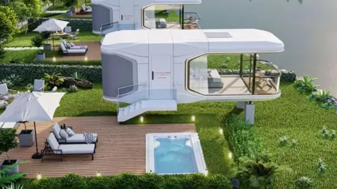 Mantianxing Modern, futuristic white villas elevated on stilts line a calm lakeshore, each with large glass walls, private wooden decks, outdoor seating, umbrellas, and small plunge pools, surrounded by lush green landscaping and trees.