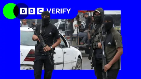 Getty Images Three Hamas fighters stand guard in Gaza. They wear balaclavas and are armed with assault rifles.