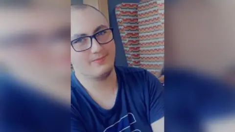 Humberside Police Family picture of Connor Richards who has dark shaven hair and is wearing glasses and a blue T-Shirt