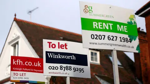 Getty Images Estate agent signs advertising properties "To Let" and ''Rent Me" stand outside residential buildings