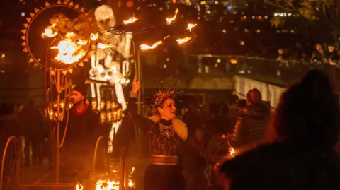 DCSDC A woman holdinga ring of fire and in costume takes part in Londonderry's Halloween festival