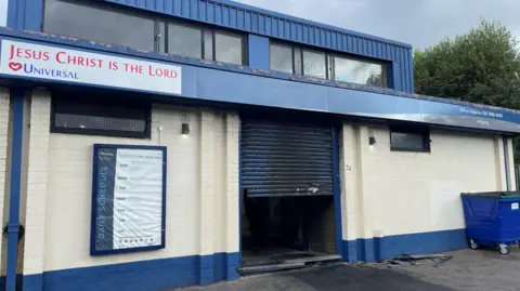 PA Damaged blue shutter of blue and cream church in Templemore Street in east Belfast