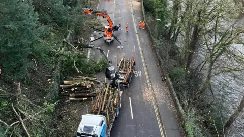 Derbyshire County Council Heavy machinery being used to clear large trees hanging over a road 