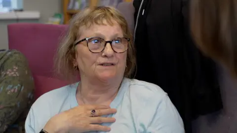 Norma Williams wearing glasses and in a light blue T-shirt
