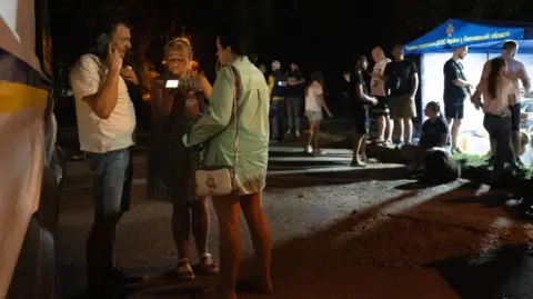 Getty Images Medical workers and psychologists provide assistance and support to local residents and victims in the neighbourhood where a military educational facility was hit by Russian missiles in Poltava