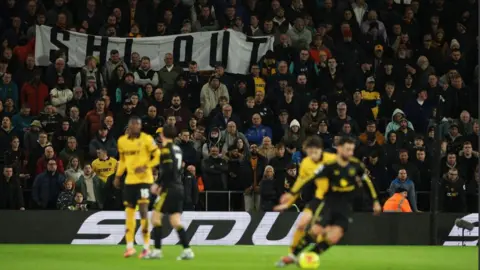 Reuters Wolverhampton Wanderers fan display a protest banner against chairman Jeff Shi in the stands during the match
