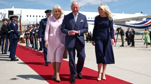 Britain's King Charles III and Queen Camilla walk with US Protocol Chief Monica Crowley as they arrive at Joint Base Andrews, Maryland, U.S., April 27, 2026
