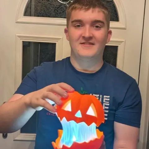 Supplied Reece holding a pumpkin decoration