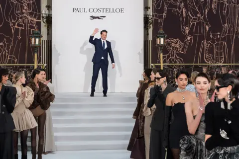 Anadolu via Getty Images Creative Director William Costelloe, son of the late designer Paul Costelloe, poses on the runway after the Autumn / Winter 2026 show at London Fashion Week in London, United Kingdom on February 19, 2026. 