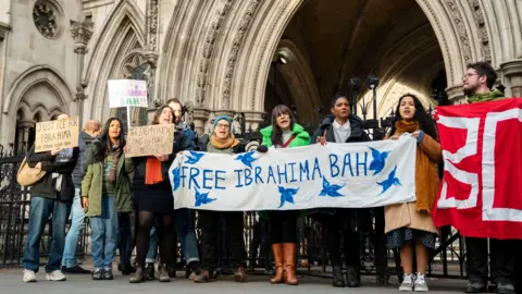 PA Media Protesters gathered outside the court house, holding banners. One says, "Free Ibrahima Bah". There are 10 people in the photo. 