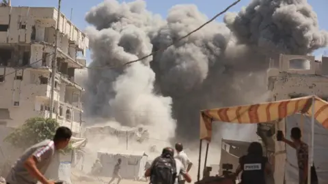 Reuters Smoke rises from an evacuated residential building which was housing displaced Palestinians, after it was hit by an Israeli air strike, in Gaza City