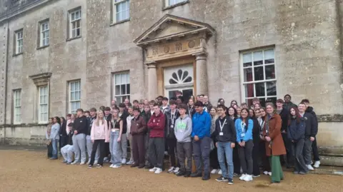 Local Democracy Reporting Service Young people stood in front of a stately home 