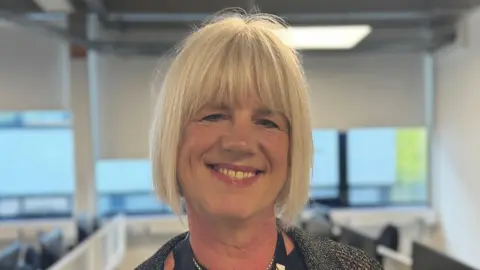 George King/BBC A head and shoulders image of a woman who is smiling while looking into the camera.