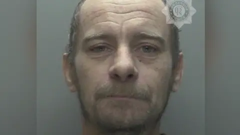 Humberside Police Police mug shot of a man with short hair and a fluffy beard and moustache. He is looking directly at the camera.