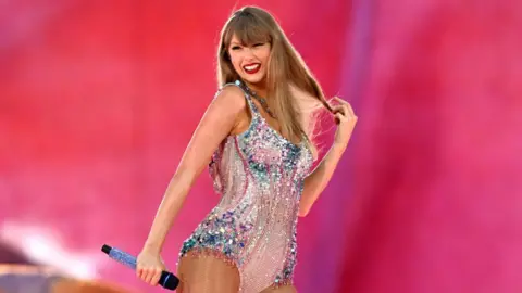 Getty Images Taylor Swift in a pastel pink and blue leotard.