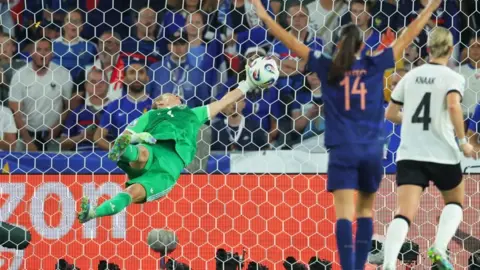 Germany's Ann-Katrin Berger, in green, leaps backwards towards the net to makes a save