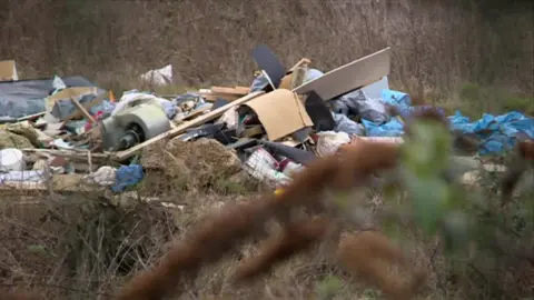 Illegally dumped waste in wasteland.