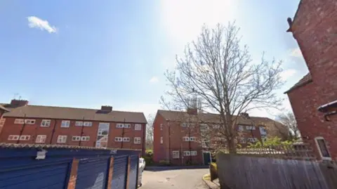 Google Flats behind blue garages