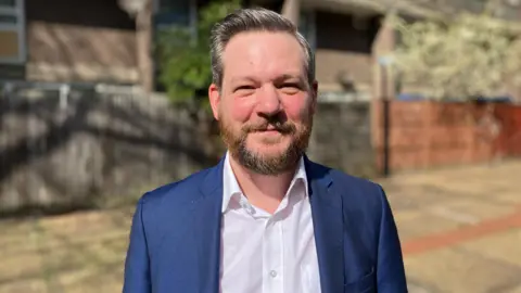 Ben amable con una camisa blanca y un blazer azul