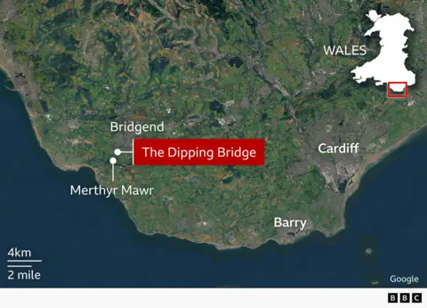 Satellite-style map of south Wales showing the coastline and surrounding countryside. A red label marks “The Dipping Bridge” inland between the coastal settlements of Merthyr Mawr and Bridgend, west of Cardiff and north of Barry. An inset outline map of Wales in the top right highlights the location area,.