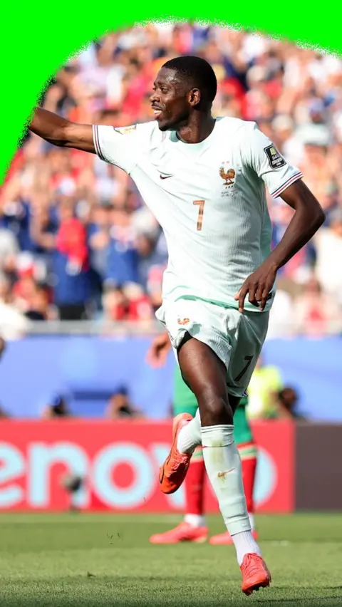 Ousmane Dembélé points to the crowd and smiles after scoring a goal in the 2026 World Cup.