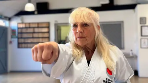 BBC Janet Farrell does a "punching" pose