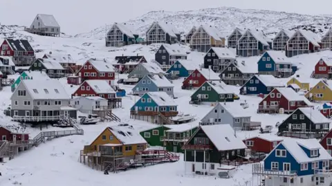 Colourful, A-line houses in the snow.