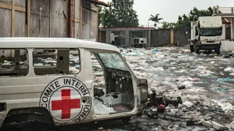 Getty Images Destroyed International Committee of the Red Cross (ICRC) vehicles lie amid debris at a looted World Food Programme warehous