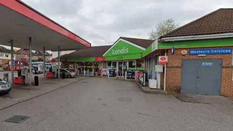 A petrol station with Londis shop, coffee and post office under a grey sky.