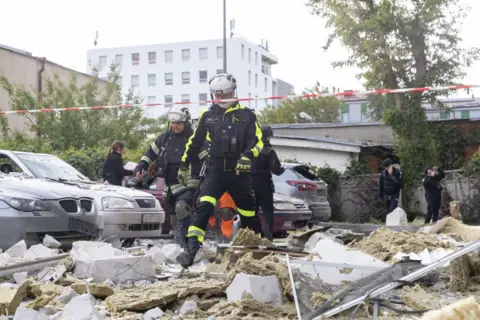  Rescue workers respond at the site on a Russian airstrike of a multi-storey residential building with a UMPB D-30 glide bomb on May 14, 2024 in Kharkiv, Ukraine