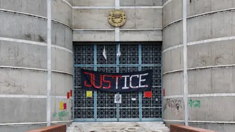 Reuters A banner saying 'justice' hangs on the entrance of Bangladesh's parliament building