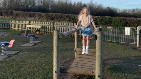 Jodie Wainwright Elemie Rose Wainwright playing on a wooden climbing frame at Plumley Park in Sheffield 