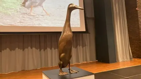 Cathy Minton/BBC The Long Boi statue is life-size and made of bronze