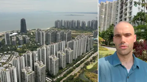Skyline of Forest City, Malaysia of the left. Man wearing blue shirt in front of buildings on the right.