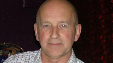 Bob Barber Bob Barber looks into the camera wearing a check shirt