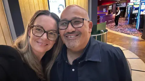 Donda Michaelas Smiling man and woman cuddling together and lookin to camera indoors