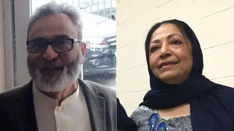 Family photograph Left to right: Adam Taju with grey hair and beard and black glasses and Hasina Taju wearing a black head scarf.