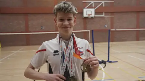 Archie Morton with the medals he's won playing badminton