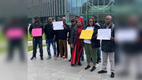 BBC Protestors holding placards outside of Teesside University