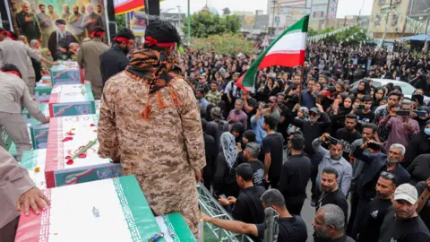 ISNA/WANA via Reuters People attend the funeral of the victims following a strike on a school in Minab, Iran, March 3, 2026.