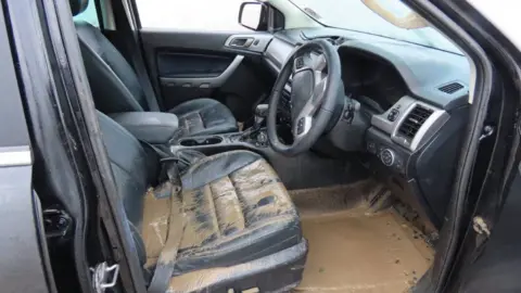 Burnham-on-Sea.com The interior of a car is pictured with brown dirty water by on a driver's seat and the floor of where the pedals are.