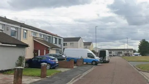 Google Housing estate with cars parked outside houses.