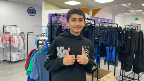 Younis in a black hoodie with his thumbs up