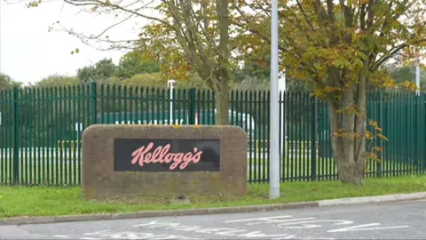 BBC An exterior view of the Kellogg's factory in Wrexham, where the sign and fencing is visible