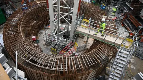 Getty Images Seorang pekerja di pembangkit listrik tenaga nuklir Hinkley Point C, yang sedang dibangun di barat daya Inggris