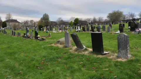 A GV of rows of graves at Riddrie Park Cemetery, on a cloudy, autumn day