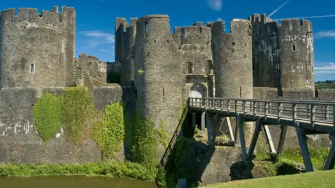 Getty Images A general view of Caerphilly castle with a moat in the foreground, and a bridge across it.